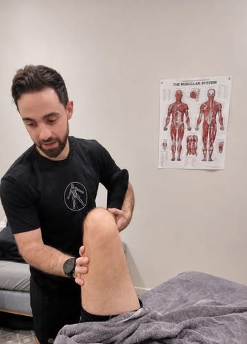 Chris moving a client's leg during a treatment